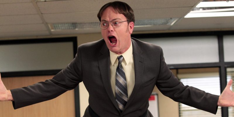Frustrated businessman shouting in office, expressing workplace dissatisfaction.