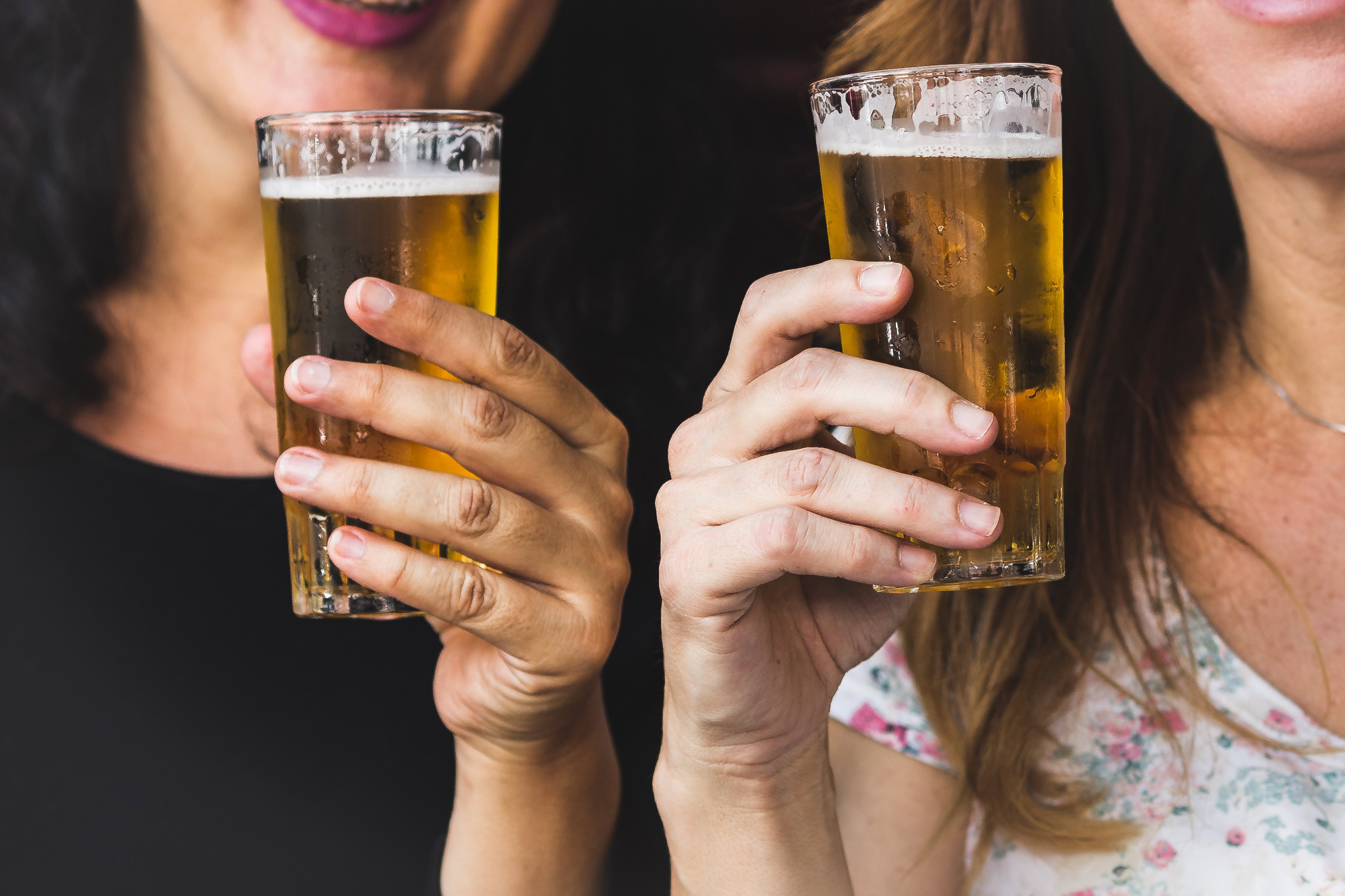 Two women toasting with pint glasses of beer
