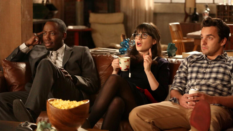 Group of friends watching a movie together on a cozy sofa.