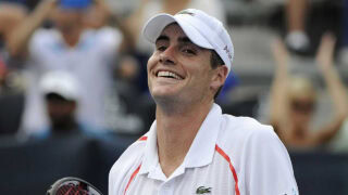 Young male tennis player smiling during a match in Greensboro, North Carolina.